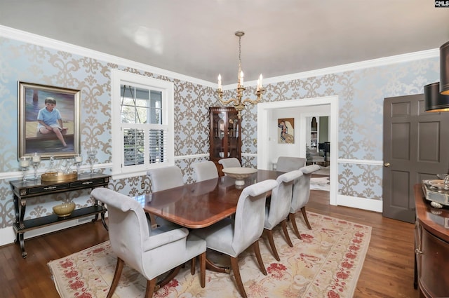 dining space with ornamental molding, wood finished floors, a notable chandelier, and wallpapered walls