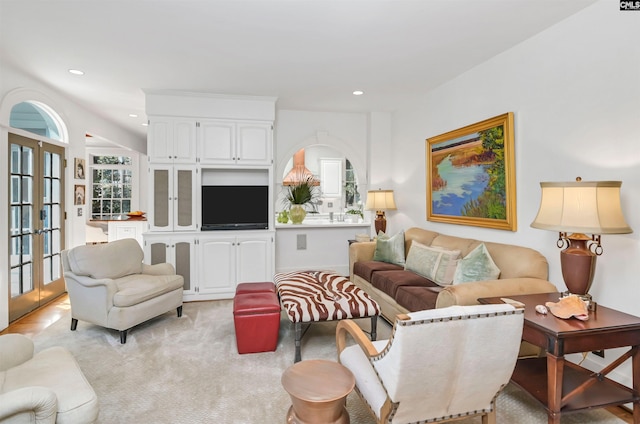 living area with a wealth of natural light, french doors, light colored carpet, and recessed lighting