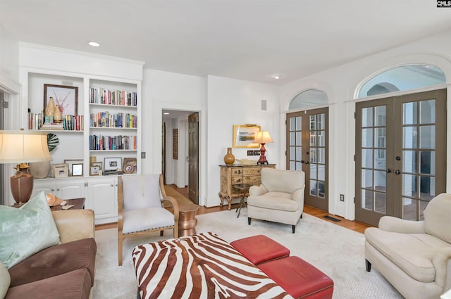 living room featuring french doors, light wood-type flooring, visible vents, and recessed lighting