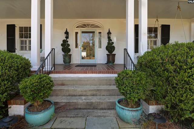 view of exterior entry featuring covered porch