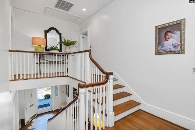 stairway featuring recessed lighting, wood finished floors, visible vents, baseboards, and attic access