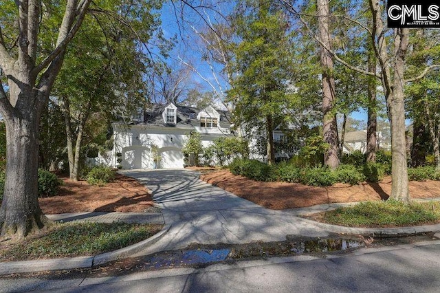 cape cod house featuring driveway and an attached garage