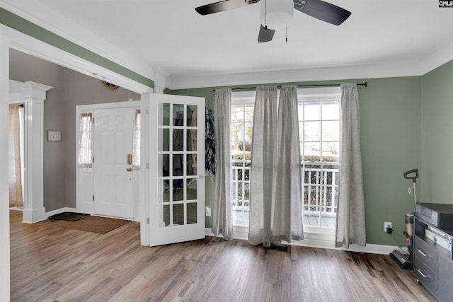 foyer entrance featuring crown molding, ceiling fan, baseboards, and wood finished floors