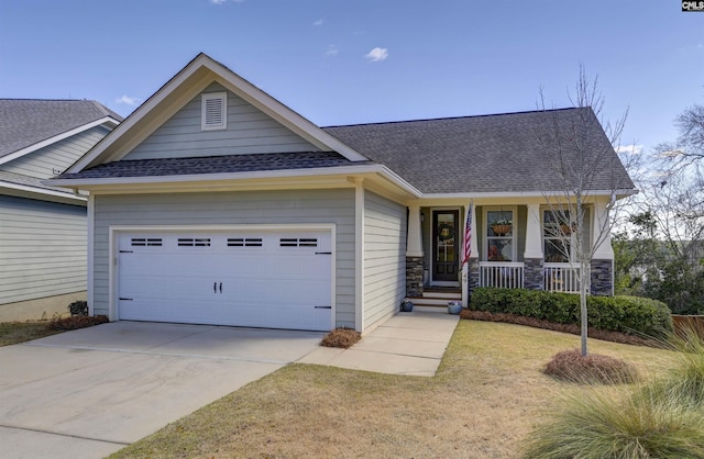 craftsman-style home with a shingled roof, covered porch, a garage, stone siding, and driveway