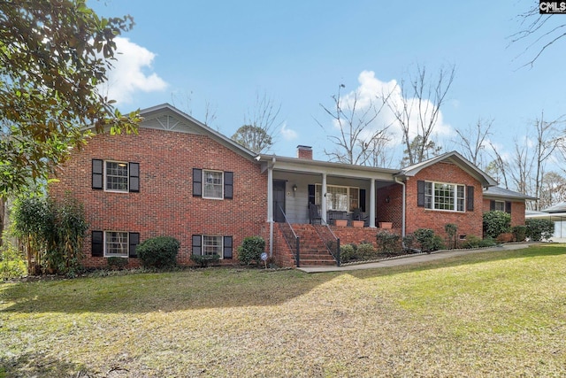 ranch-style house with a porch, a chimney, a front lawn, and brick siding