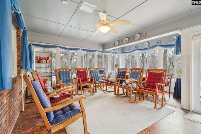 sunroom / solarium featuring a ceiling fan