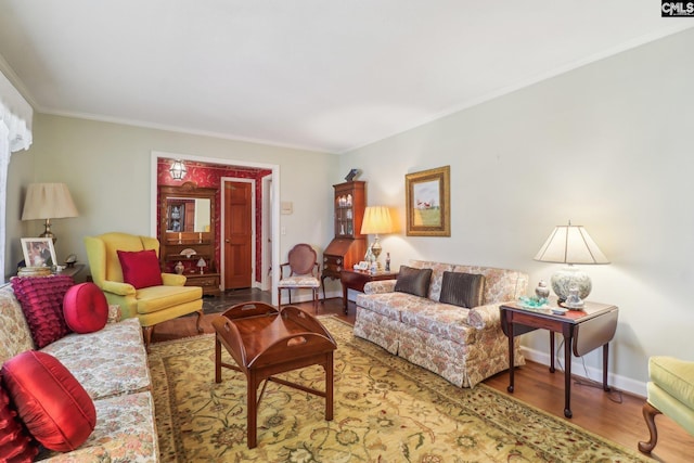 living area featuring baseboards, wood finished floors, and ornamental molding