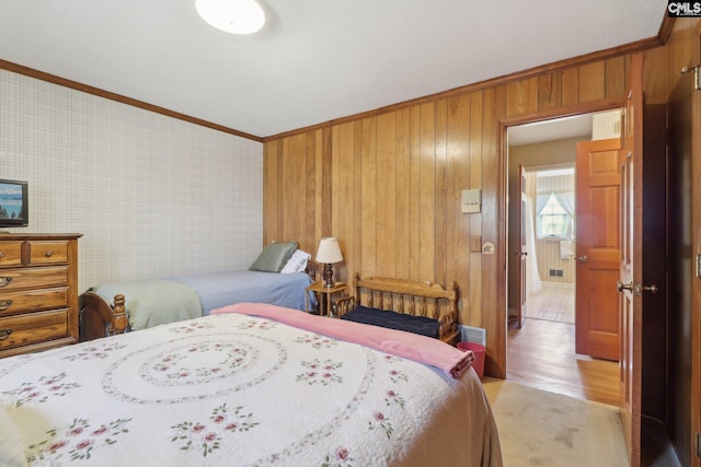 bedroom with wallpapered walls, ornamental molding, and light wood-style floors