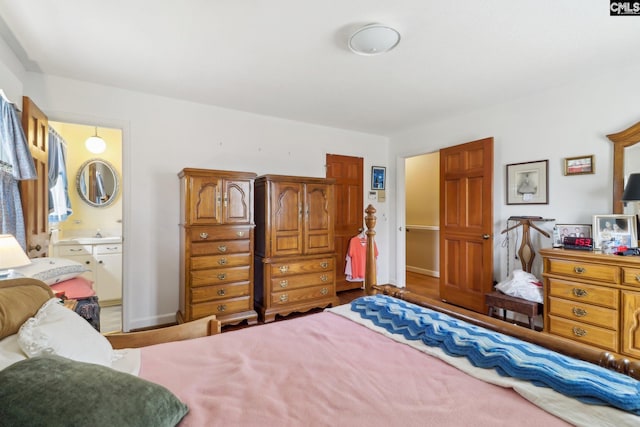 bedroom featuring ensuite bathroom and baseboards