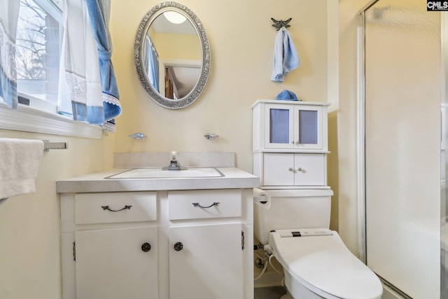 full bath featuring toilet, a shower stall, and vanity