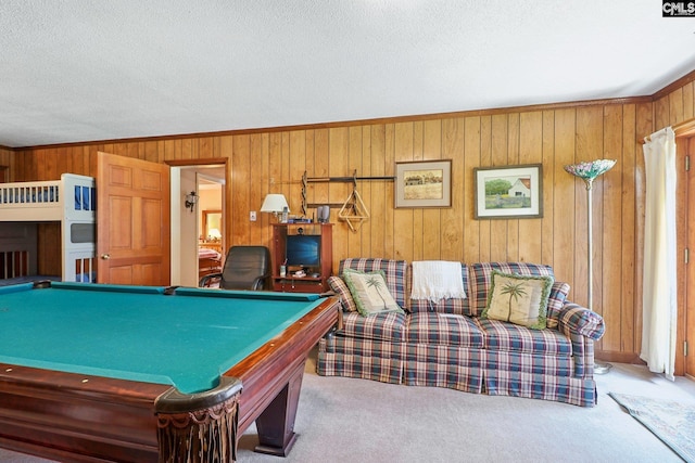 recreation room featuring carpet floors, wood walls, and a textured ceiling