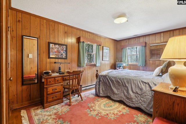 bedroom featuring a baseboard radiator, wooden walls, and wood finished floors