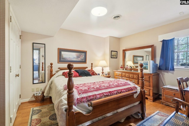 bedroom featuring baseboards, visible vents, and light wood-style floors