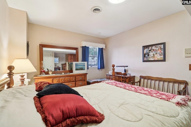 bedroom featuring wallpapered walls and visible vents