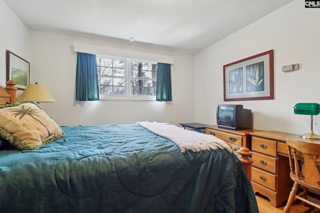 bedroom with light wood-style flooring and a textured ceiling