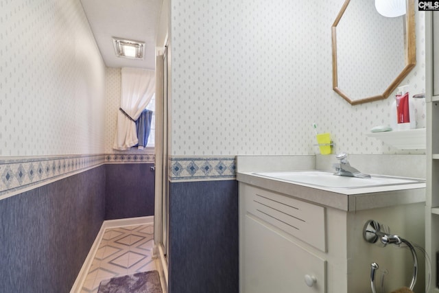 bathroom with vanity and wallpapered walls