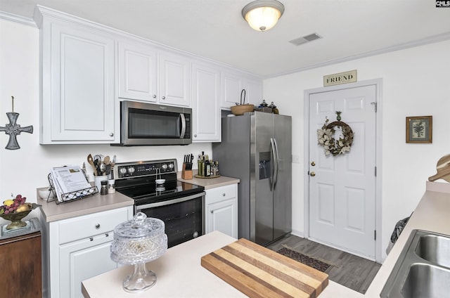 kitchen with light countertops, appliances with stainless steel finishes, visible vents, and white cabinets