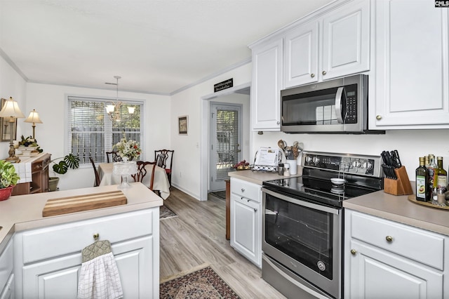 kitchen with stainless steel appliances, a wealth of natural light, light countertops, and white cabinetry