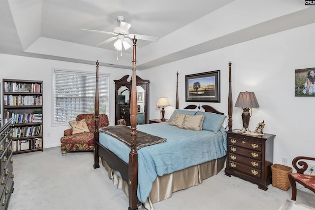 bedroom with baseboards, a ceiling fan, a raised ceiling, and carpet flooring