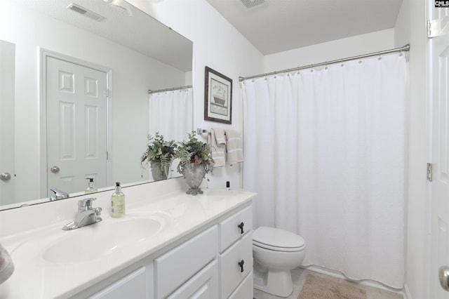 bathroom featuring visible vents, vanity, and toilet