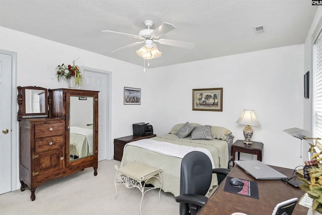 bedroom with light carpet, ceiling fan, and visible vents