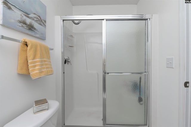 bathroom with a shower stall and toilet