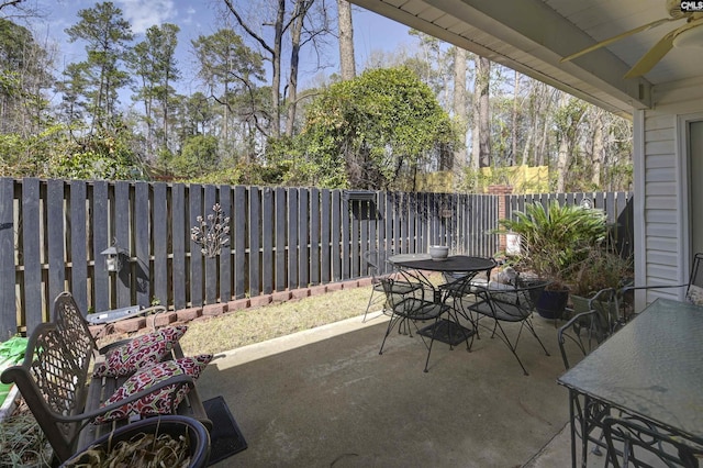 view of patio featuring a ceiling fan, outdoor dining area, and a fenced backyard