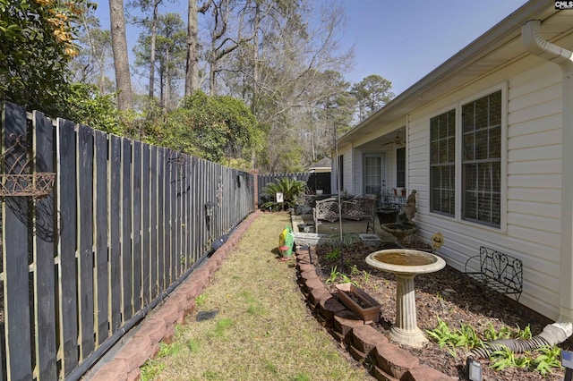 view of yard featuring a fenced backyard, ceiling fan, and a patio