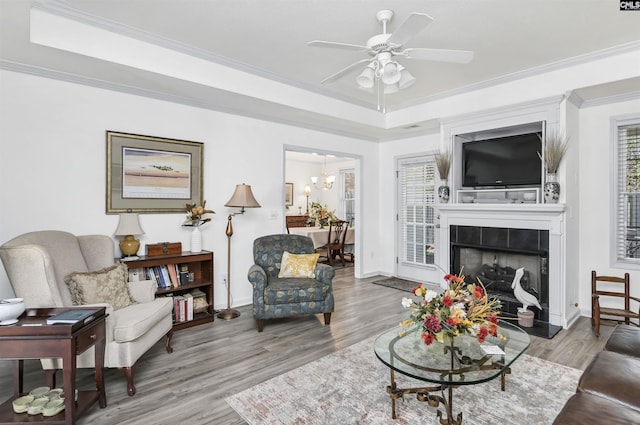 living room featuring a healthy amount of sunlight, ornamental molding, and a raised ceiling