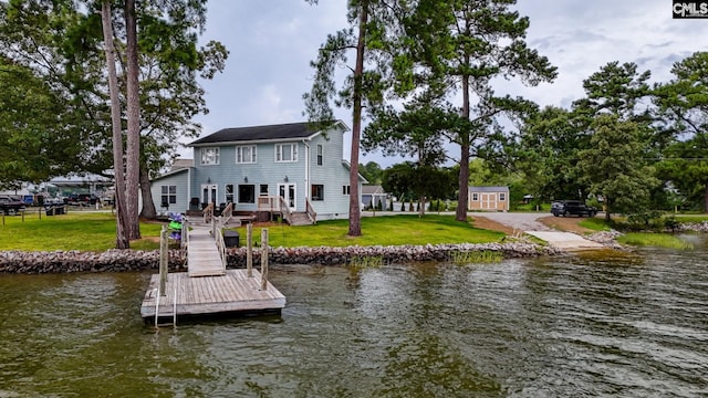 rear view of house featuring a lawn and a water view