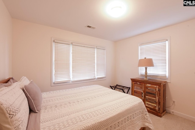 bedroom featuring light carpet, visible vents, and baseboards