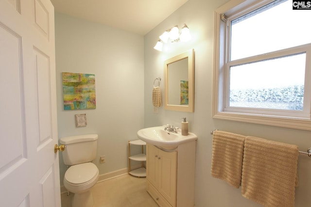 bathroom featuring baseboards, vanity, and toilet