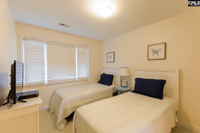 bedroom featuring light carpet, visible vents, and baseboards