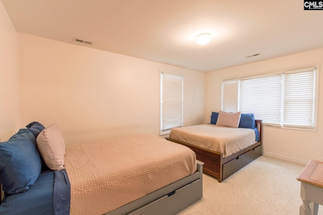 bedroom with light carpet, visible vents, and baseboards