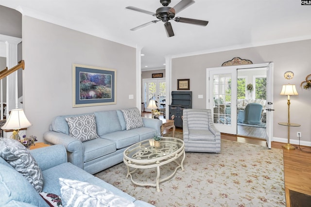 living room with baseboards, a ceiling fan, ornamental molding, wood finished floors, and french doors