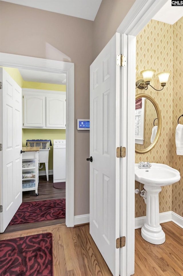 bathroom featuring washer / dryer, wood finished floors, baseboards, and wallpapered walls