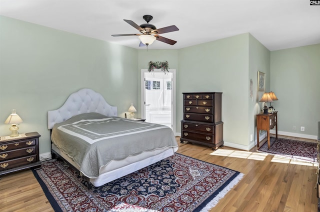 bedroom with light wood-style flooring, baseboards, and a ceiling fan