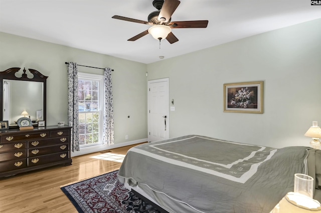 bedroom featuring ceiling fan, light wood finished floors, and baseboards