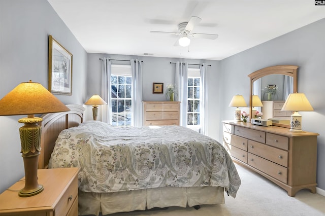 bedroom with a ceiling fan, light colored carpet, and visible vents