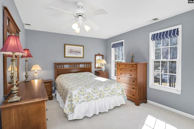 bedroom featuring baseboards, visible vents, ceiling fan, and light colored carpet