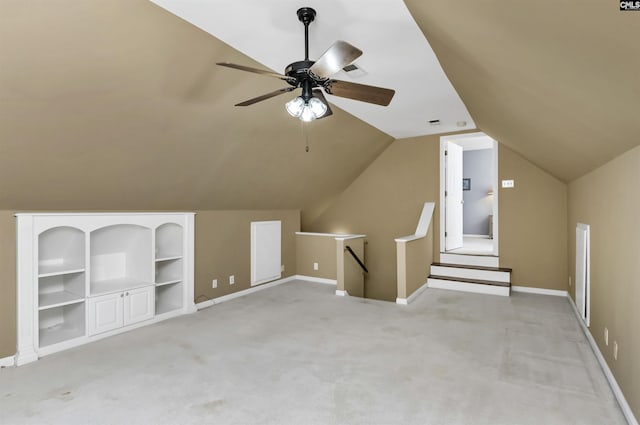 bonus room with lofted ceiling, light carpet, baseboards, and built in features