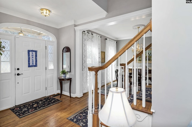 entryway featuring baseboards, stairs, ornamental molding, and wood finished floors