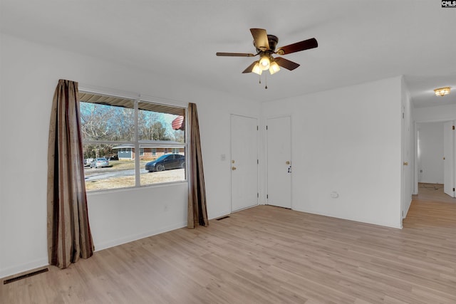 spare room with ceiling fan, visible vents, and light wood-style floors