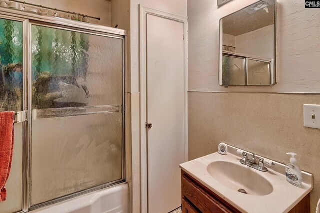 bathroom featuring vanity and bath / shower combo with glass door