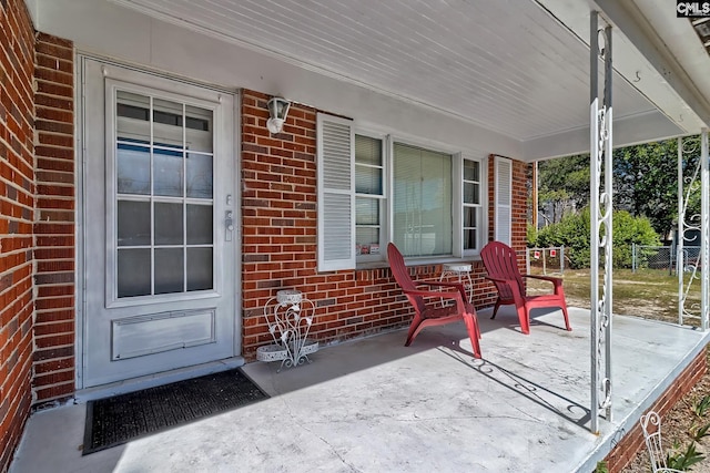 property entrance with covered porch and brick siding