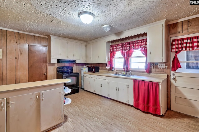 kitchen with black appliances, a sink, light countertops, and under cabinet range hood