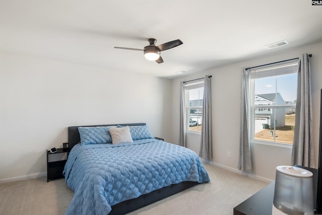 carpeted bedroom featuring baseboards, visible vents, and ceiling fan