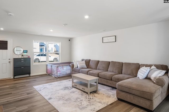 living area featuring baseboards, wood finished floors, and recessed lighting