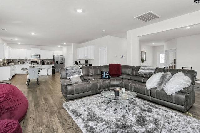 living room featuring visible vents, recessed lighting, and wood finished floors