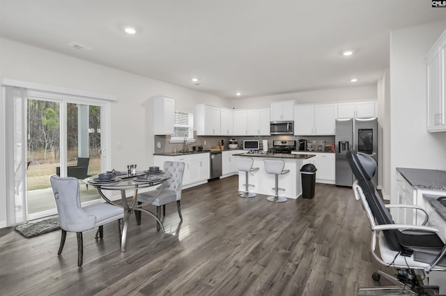 dining room with dark wood-style floors, visible vents, and recessed lighting